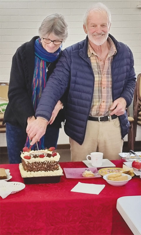 Jenny and husband John cutting a cake